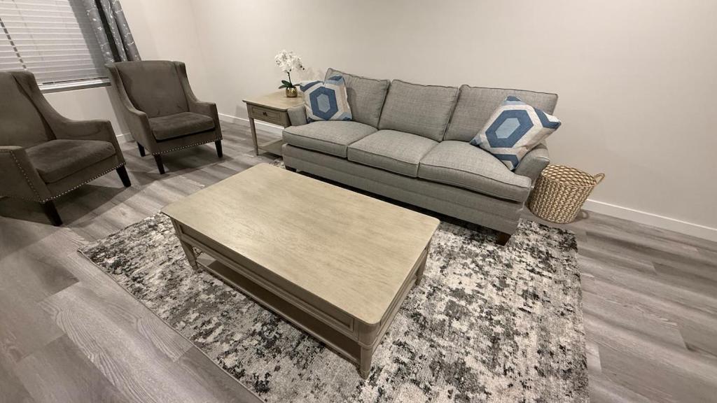 un salon avec un canapé et deux chaises dans l'établissement Pura vida Apartment, à Hickory