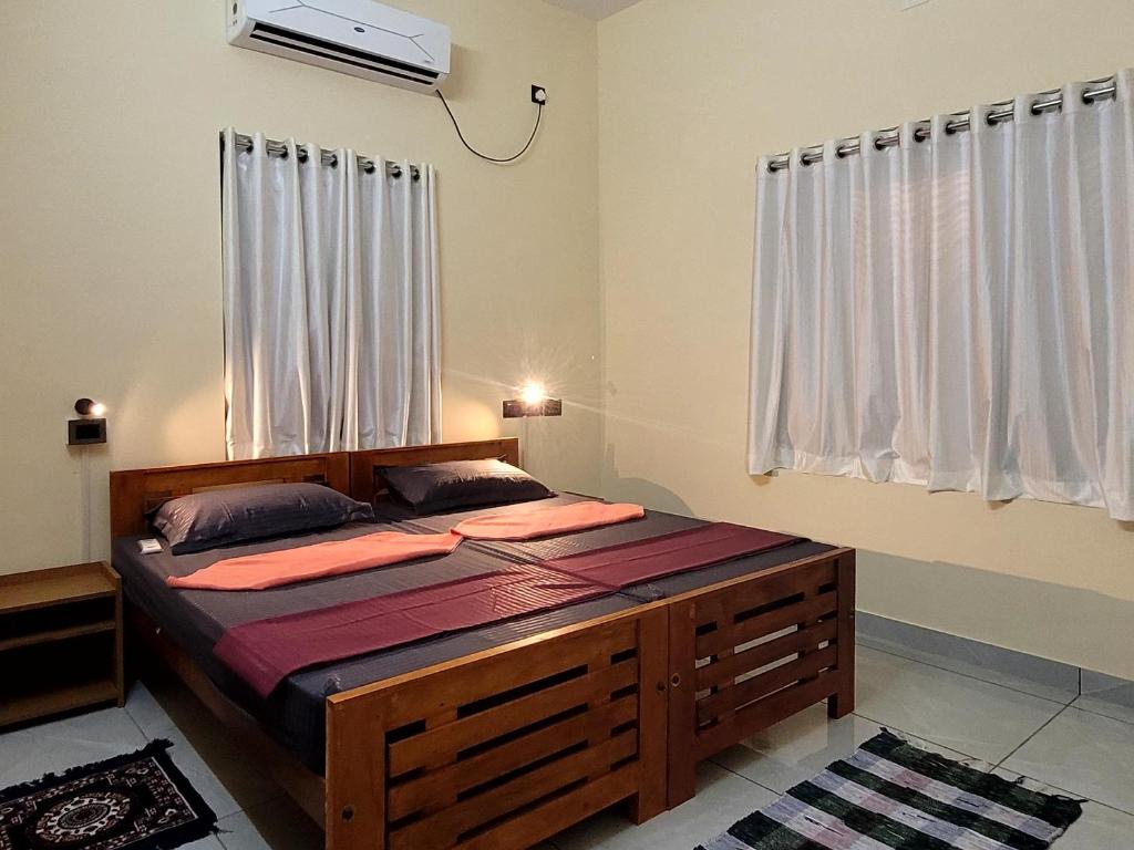 a bedroom with a large wooden bed in a room at Roameo, Varkala - A Cowork by The Hostel Stories in Varkala
