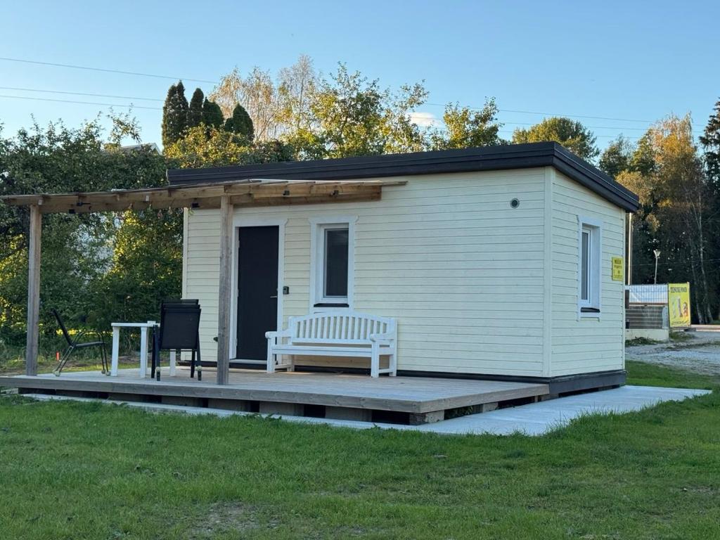 ein winziges Haus mit einer Bank auf dem Deck in der Unterkunft Teenuse loft 2 in Teenuse