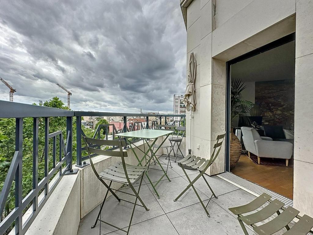 a balcony with a table and chairs on a building at Classy apartment with terrace in Saint-Ouen