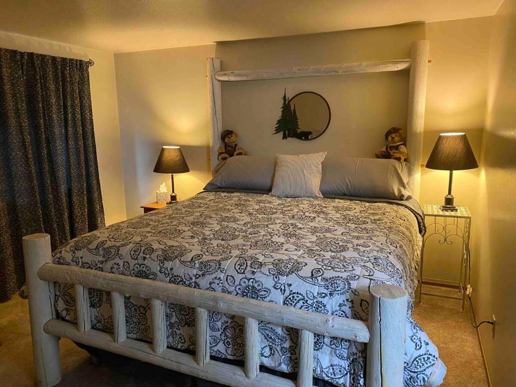 een slaapkamer met een groot bed met een houten frame bij Cozy Bear Condo in Brian Head