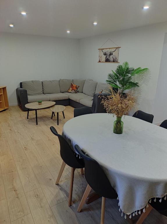 un soggiorno con un tavolo bianco e un divano di Gîte de la Rouge Roye a Nompatelize