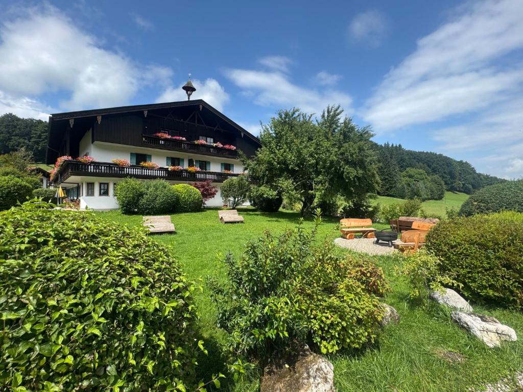 a building in a field with trees and grass at ciao-aschau Gschwendtnerhof Ap19 SchölzkeM in Aschau