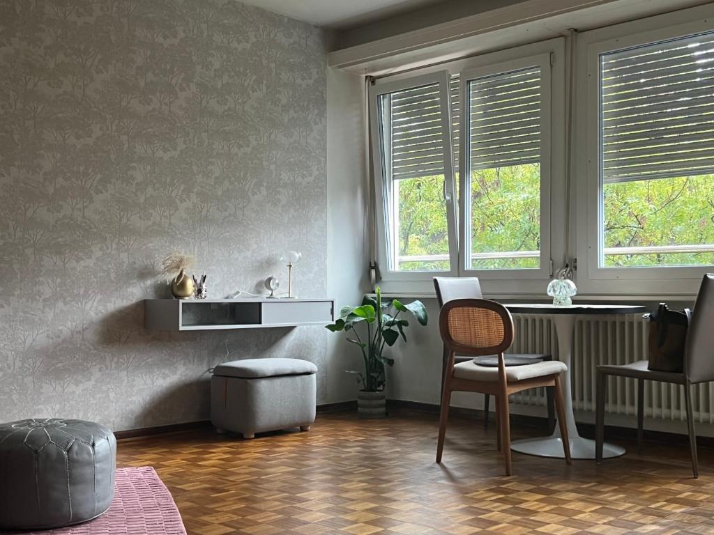 a living room with a chair and two windows at Champel Cozy Studio in Geneva