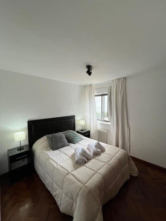 a bedroom with a bed with two towels on it at Departamento Costa del Lago Bariloche in San Carlos de Bariloche