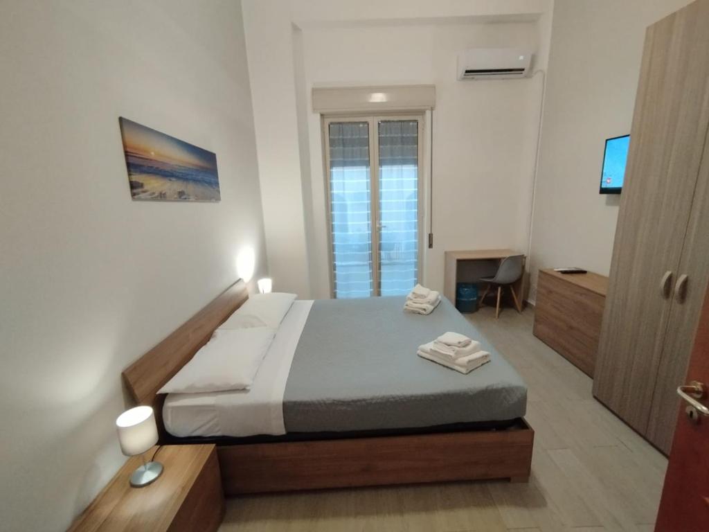een slaapkamer met een bed en een televisie. bij GiGi Affittacamere in Siracusa
