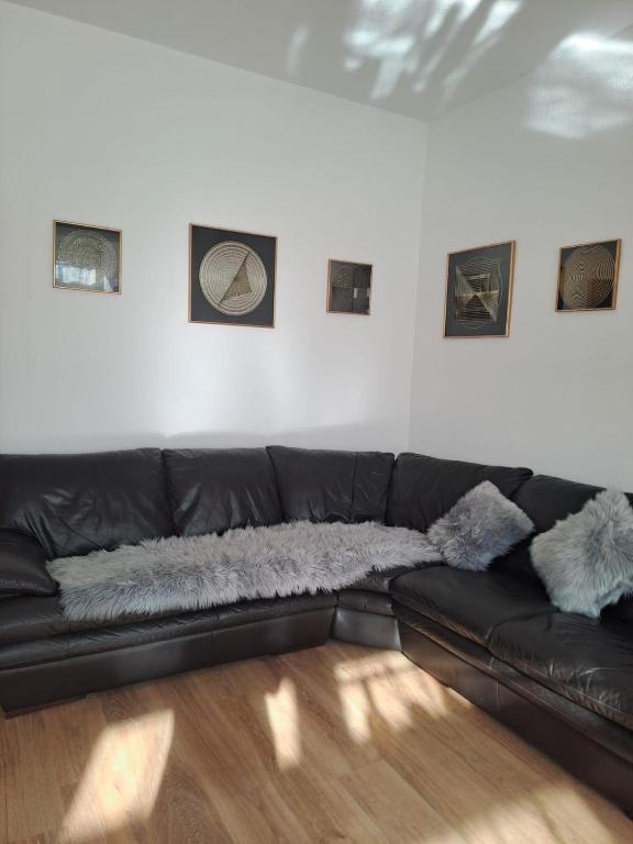 a black leather couch in a living room at Gemütliche 4-Zimmer Wohnung mit 7 Schlafplätzen in Chemnitz