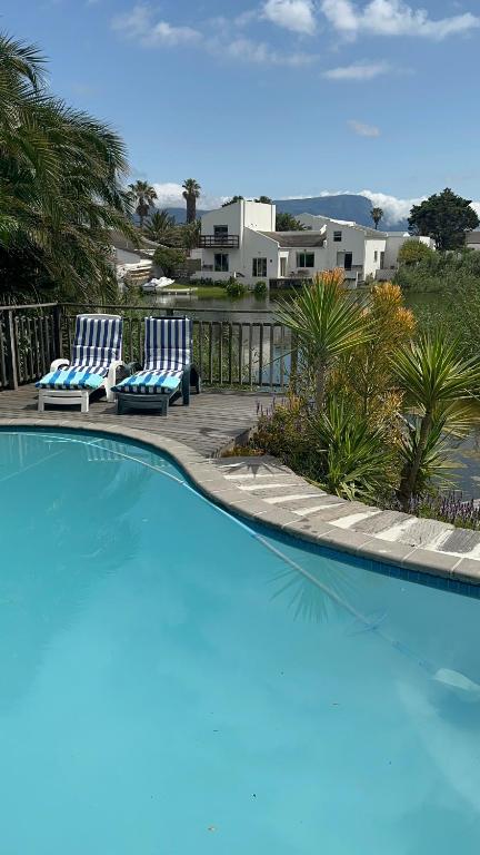 two blue chairs sitting next to a swimming pool at Bella Vista Lago in Marina da Gama