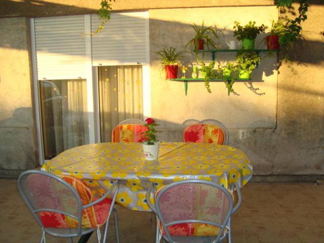 een gele tafel en stoelen met een gele en rode tafel bij Blue Holidays Apartment in Šibenik