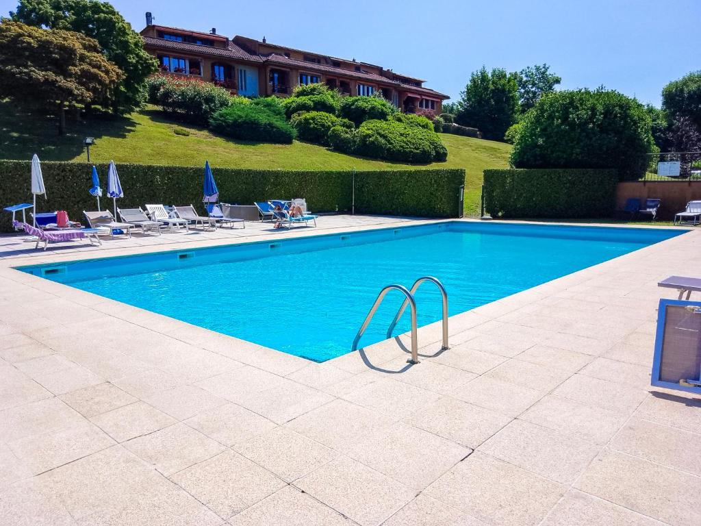 CissanoにあるResidenza San Martinoの背景に家があるスイミングプール(椅子付)