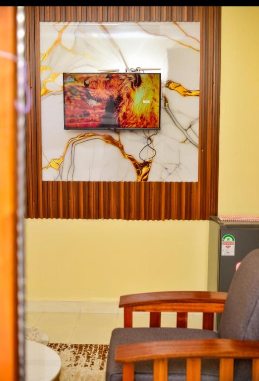 a living room with a tv on a wall at Mylon deluxe in Nakuru