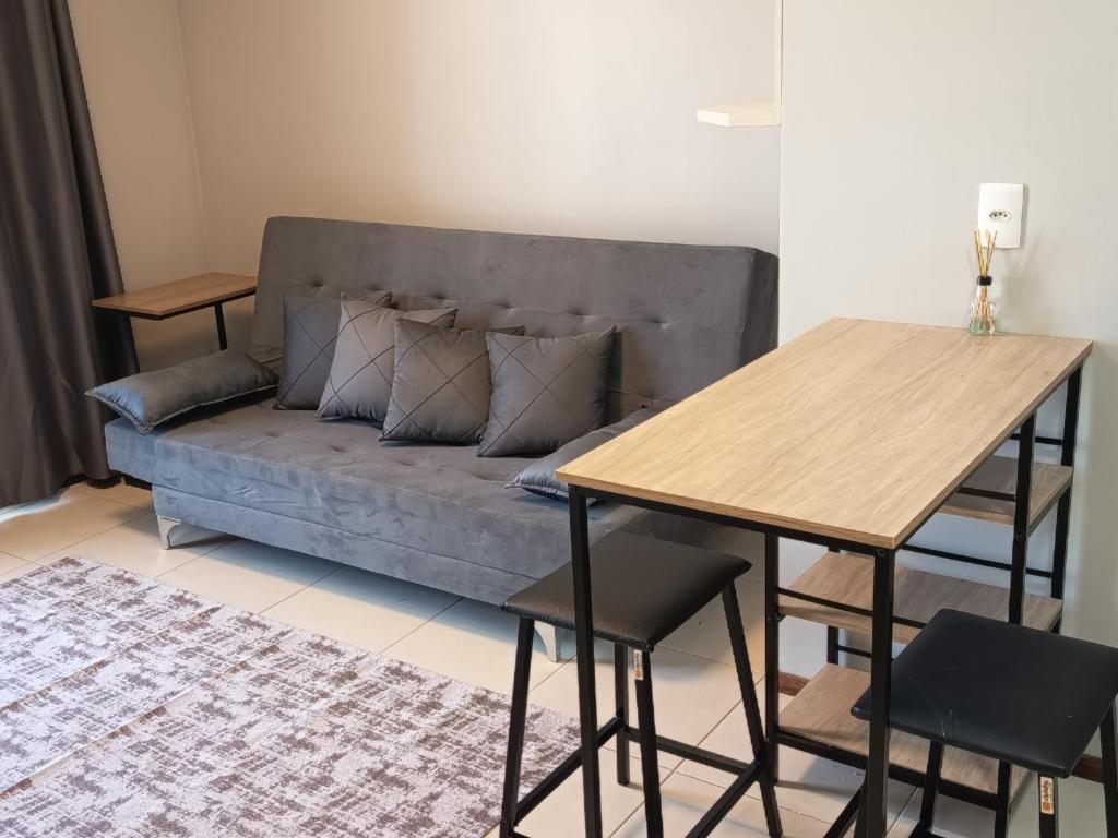 a couch in a living room with a table and a bench at VIVA - Centro - Garagem - Apt 1 Dormitório in Santa Maria