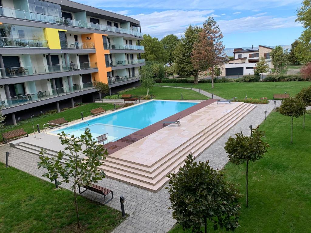 Un edificio de apartamentos con piscina en un patio. en Relax Apartman Siófok, en Siófok