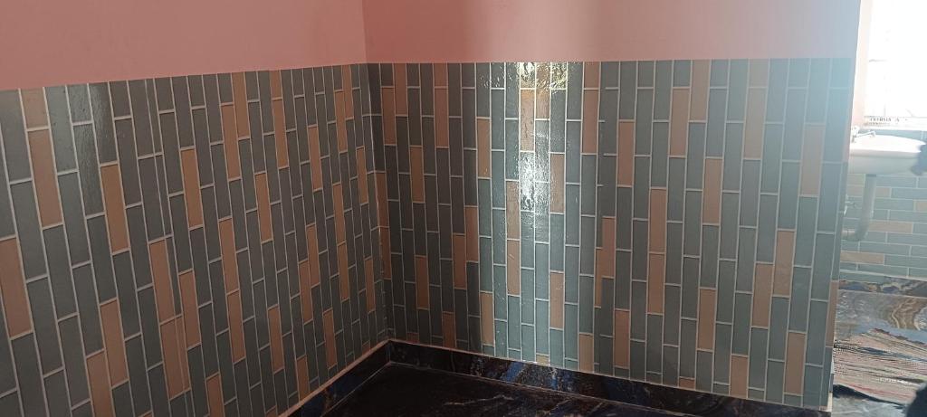 La salle de bains est pourvue d'une douche avec du carrelage brun. dans l'établissement Sona rooms, à Coimbatore