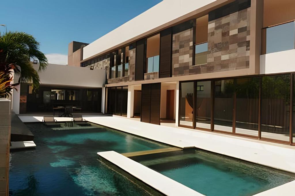 ein Gebäude mit einem Swimmingpool vor einem Gebäude in der Unterkunft Waua BSM| 6 suítes, Piscina, hidro, sala de jogos, in Barra de São Miguel