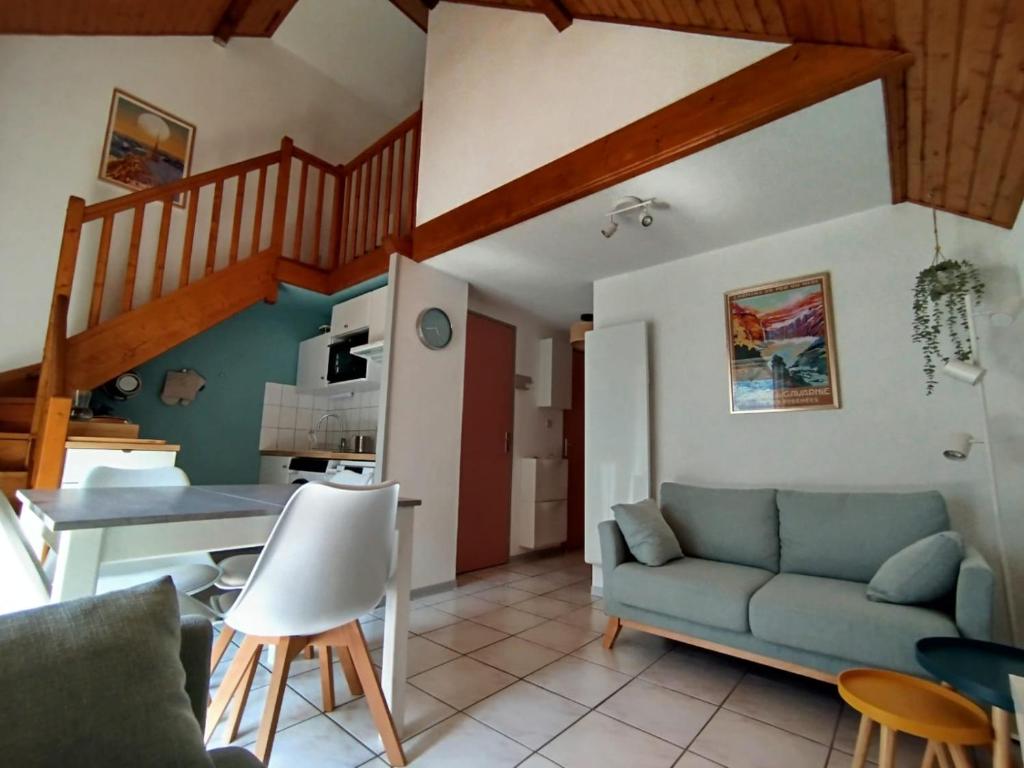 a living room with a couch and a staircase at Alt'à Luz, Duplex 2 étoiles, 4 Pers , Ménage inclus in Luz-Saint-Sauveur