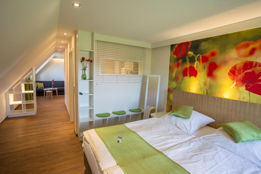 een slaapkamer met een bed en een schilderij aan de muur bij Gasthof Linden & Wildkräuterhotel in Windelsbach