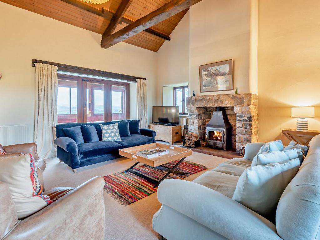 a living room with blue couches and a fireplace at 3 Bed in Kirkby Stephen 93379 in Orton