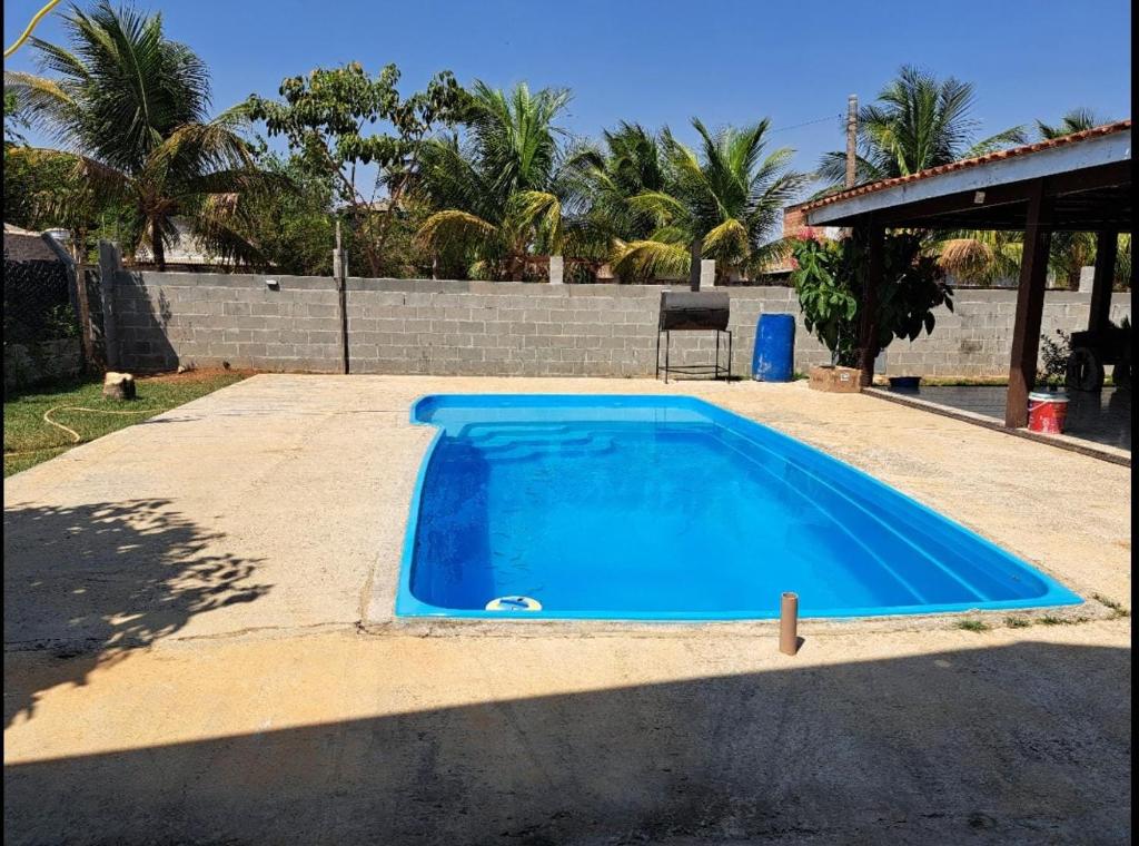 a large blue swimming pool in a yard at Casa de Campo em Sinop in Sinop