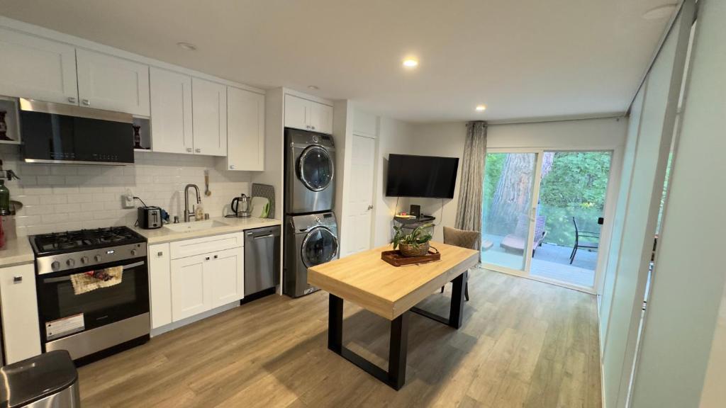 Una cocina con gabinetes blancos y una mesa en ella. en Joyful Place, en Sherman Oaks