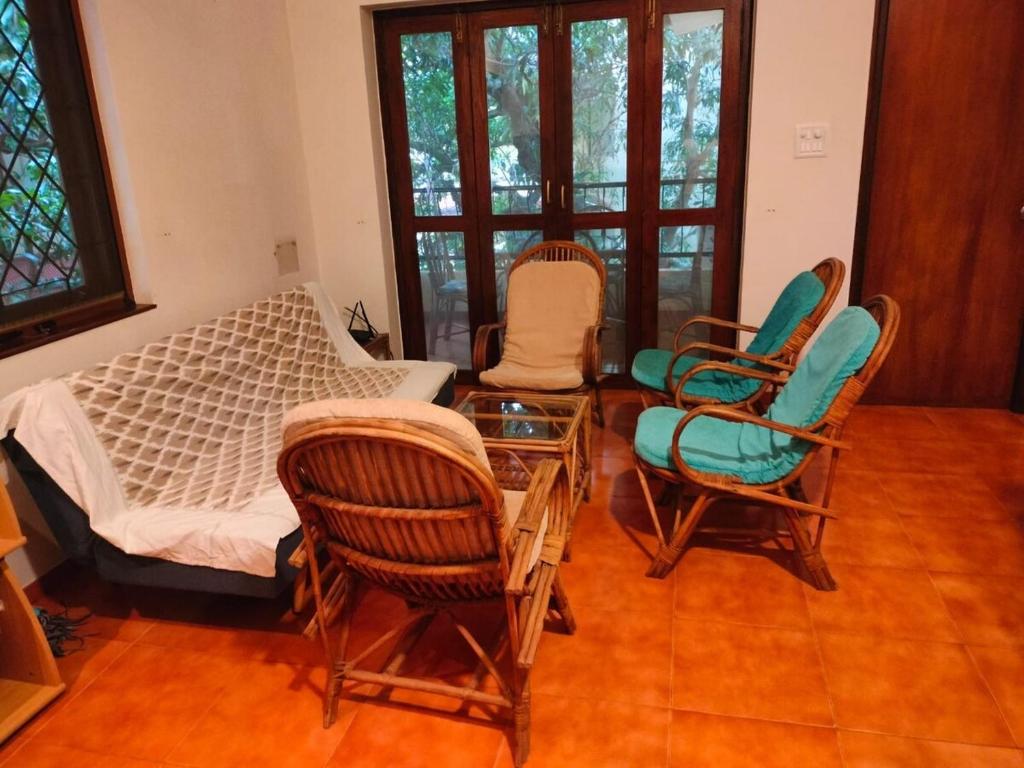 a room with chairs and a bed and a table at Navilehomestay in Candolim