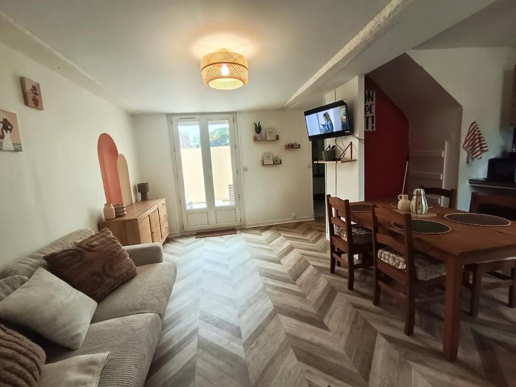 a living room with a couch and a table at La Parenthèse Picarde Maison de ville 2 chambres in Troissereux