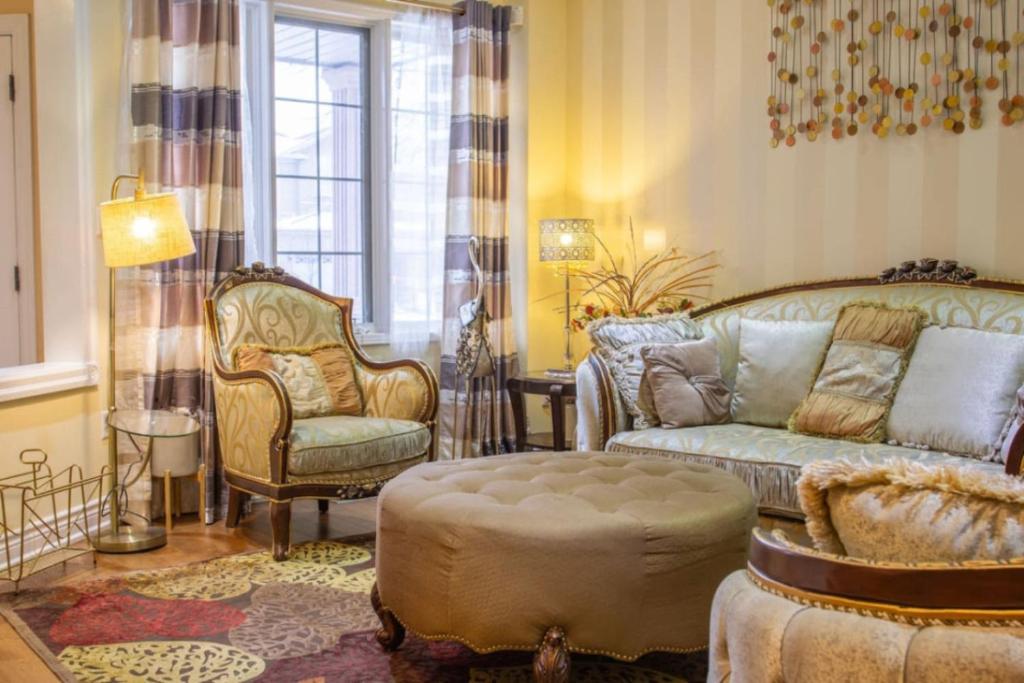 una sala de estar con un sofá y una silla en Royal Luxury Central Home with Gazebo By Toronto, en Brampton