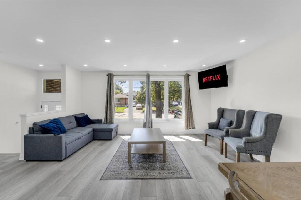 una sala de estar con un sofá y dos sillas en Spacious 6BR Getaway Sleeps 16 Yard and Parking, en Brampton