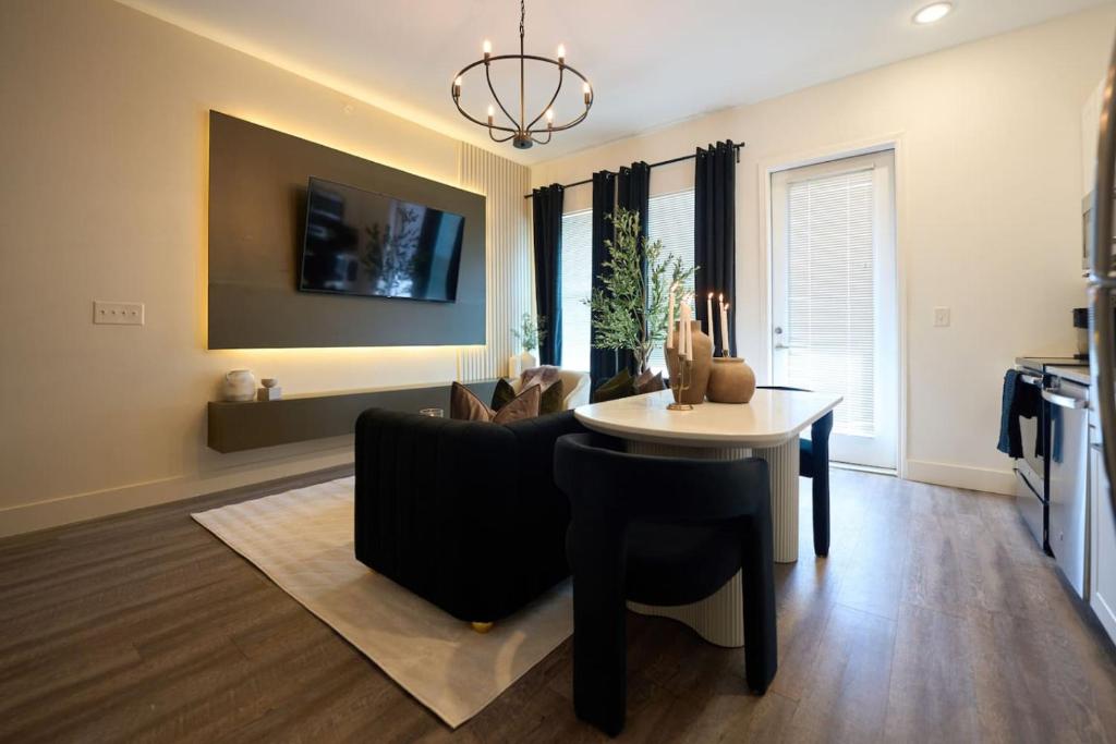 ein Wohnzimmer mit einer schwarzen Couch und einem Tisch in der Unterkunft Comfortable Atlanta Stay Near Mercedes-Benz Stadium in Atlanta