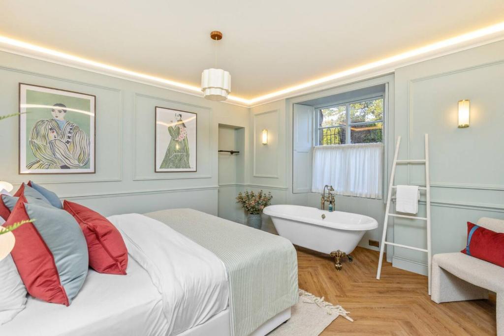 スターリングにあるThe Kings Park Luxury Residenceのベッドルーム1室(ベッド1台、バスタブ、窓付)