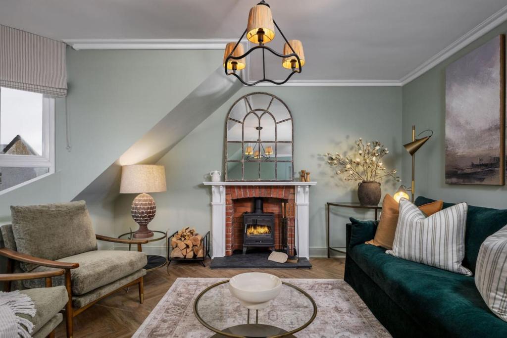 a living room with a fireplace and a green couch at Ledi Lookout Callander in Callander