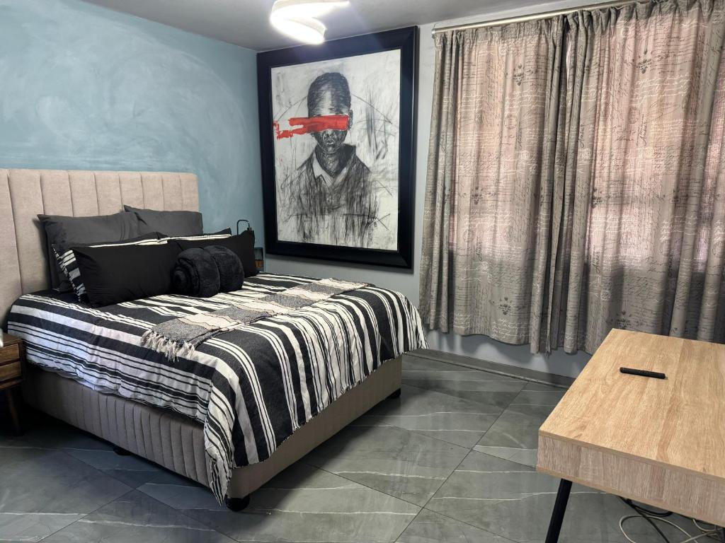 ein Schlafzimmer mit einem Bett und einem Bild eines Mannes in der Unterkunft Davenport Durban in Durban