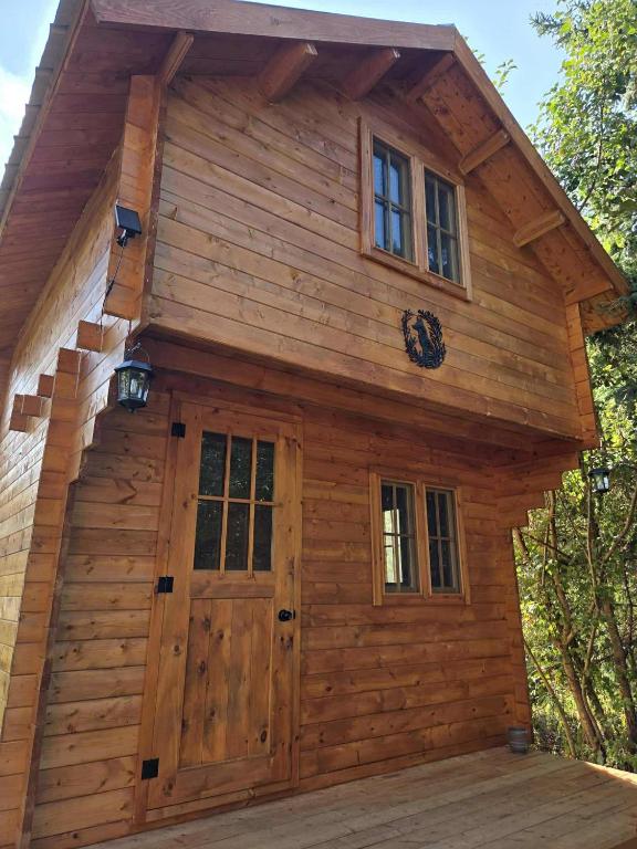 Saint-OnésimeにあるLa Taniere du Renardの大きなドアと窓のあるログキャビン