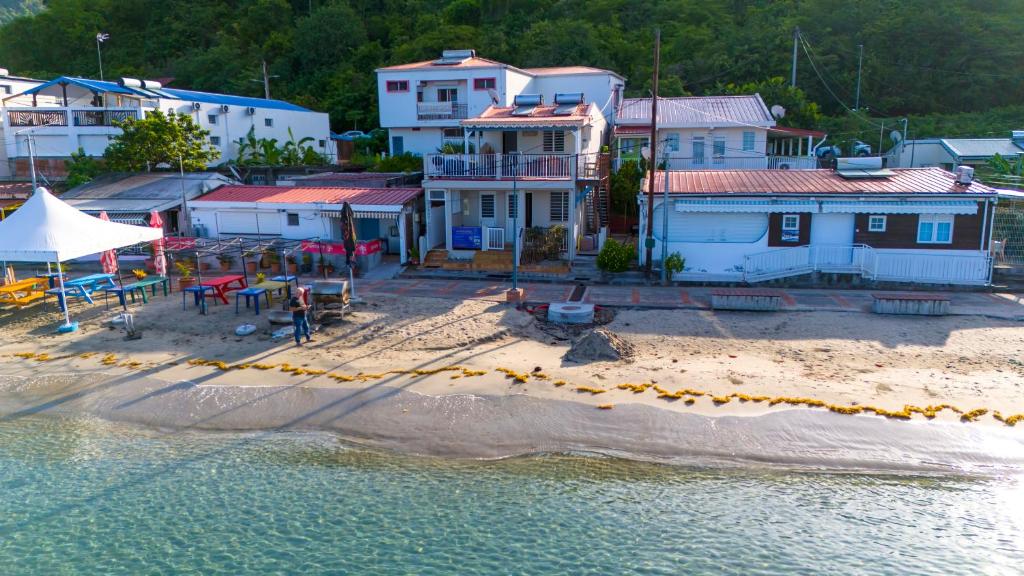 a group of houses on a beach next to the water at Lez'arlet Plage in Les Anses-dʼArlets