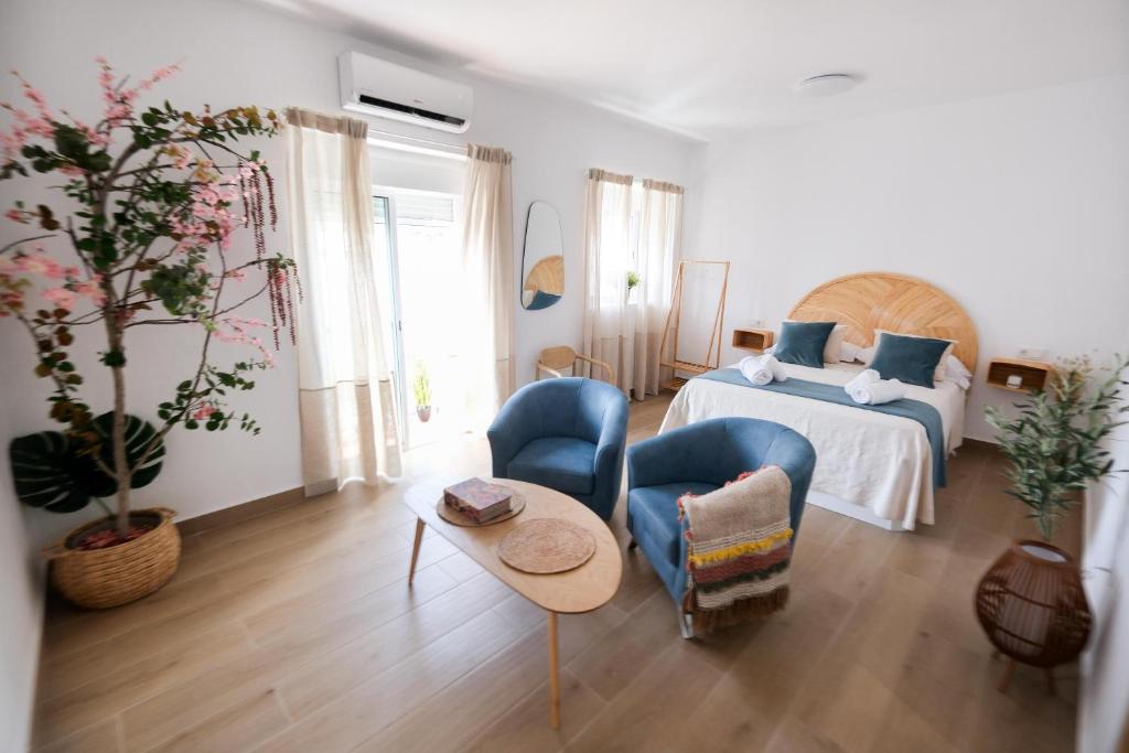 una camera da letto con un letto, due sedie e un tavolo di La Zarzamora a Jerez de la Frontera