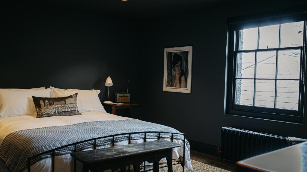 a black bedroom with a bed and a window at Smiths Townhouse in Broadstairs