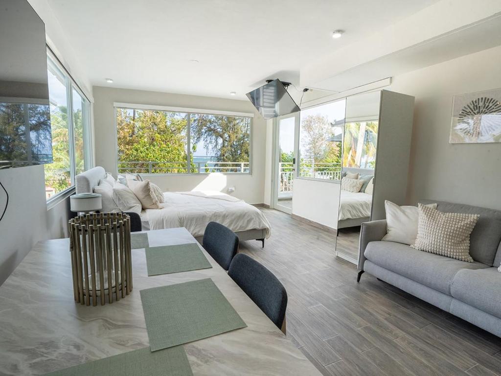 a bedroom with a bed and a living room at AQUA Terrazas 6&7 3BR Fun & Dining by the Beach in Mameyal