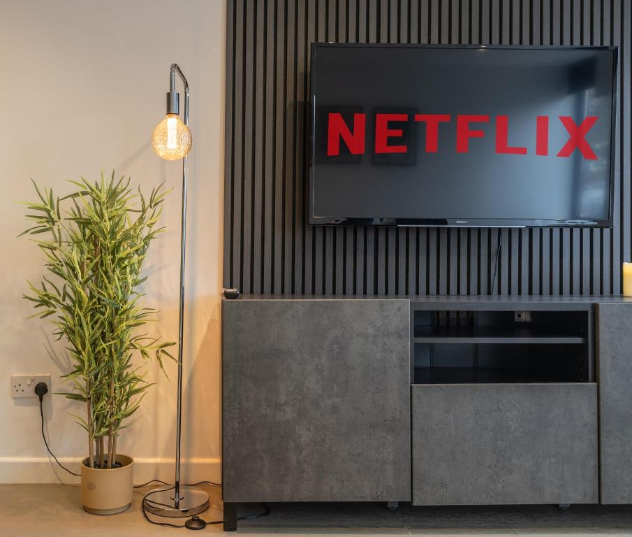 un televisor sentado en la parte superior de un centro de entretenimiento en Stylish Apartment With Parking Close To Birmingham, en Birmingham