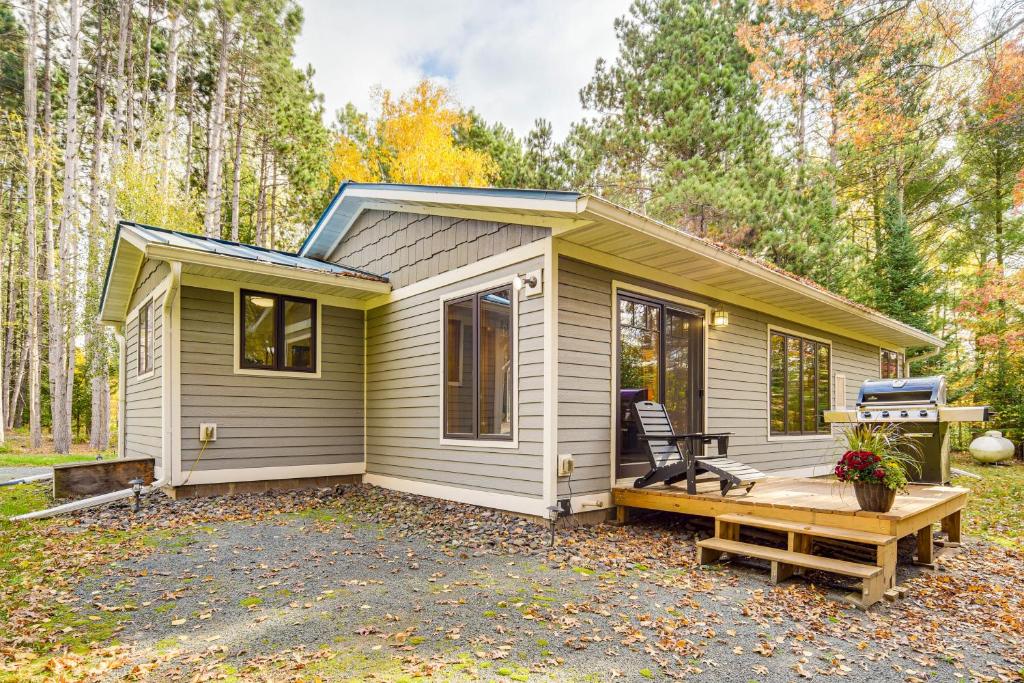 a tiny house in the woods with a bench at Riverbend Retreat on 7 Acres with River Access! in Webster