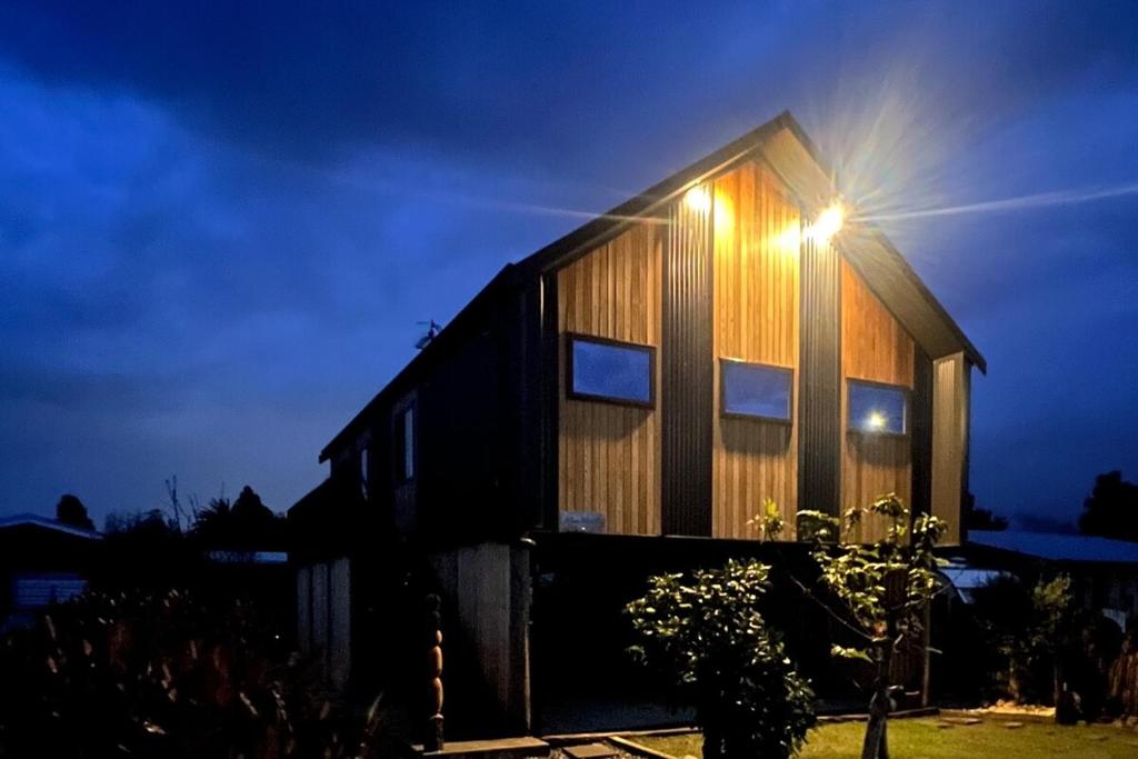 a house with a light on the side of it at Slice of paradise in Haumoana