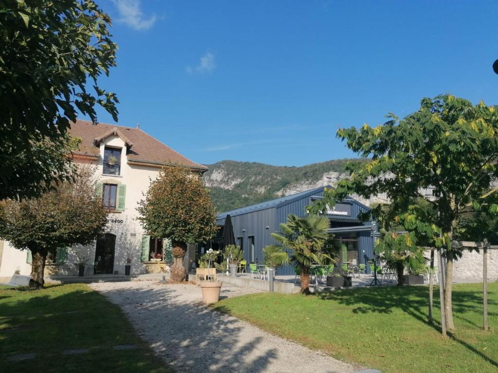 a house with a garden and trees in front of it at Gite la Cure Gourmande en Chartreuse in Saint-Christophe