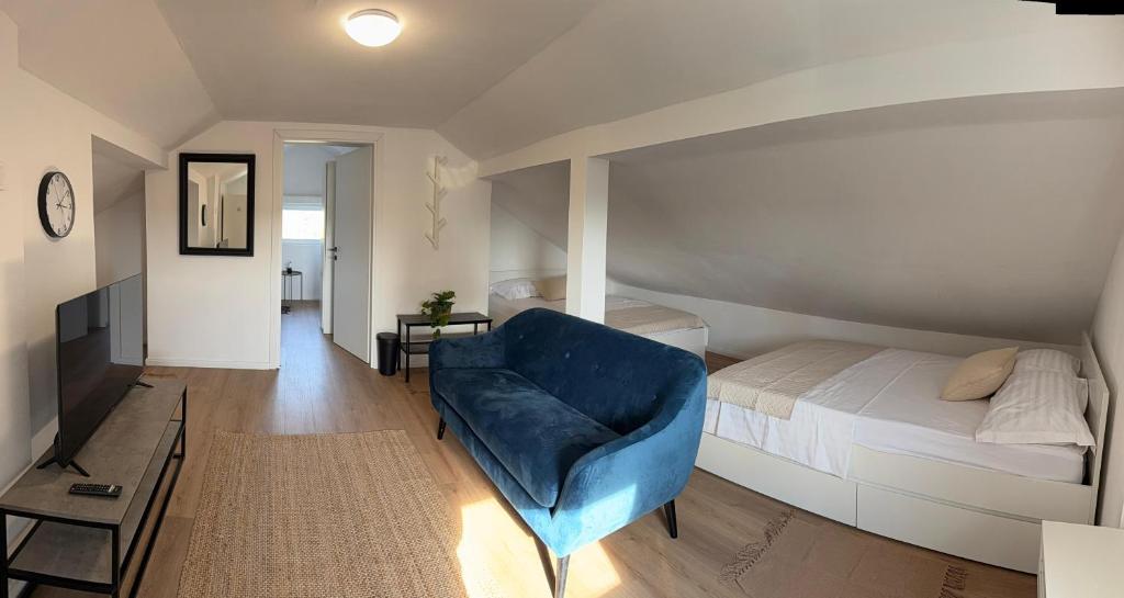 ein Schlafzimmer mit einem Bett und einem blauen Stuhl in der Unterkunft Family House Roza in Gračec