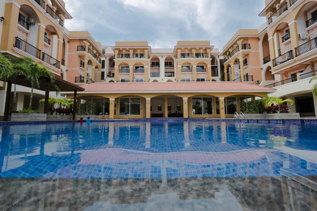 a large swimming pool in front of a building at Modern 1BHK by Kastra Homes, Siolim in Cunchelim