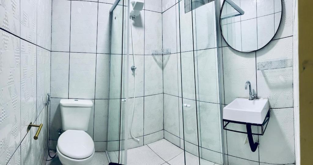 un bagno con un water, un lavandino e uno specchio di Casa espaçosa, 6 pessoas a 15 min dos eventos COP30 a Belém