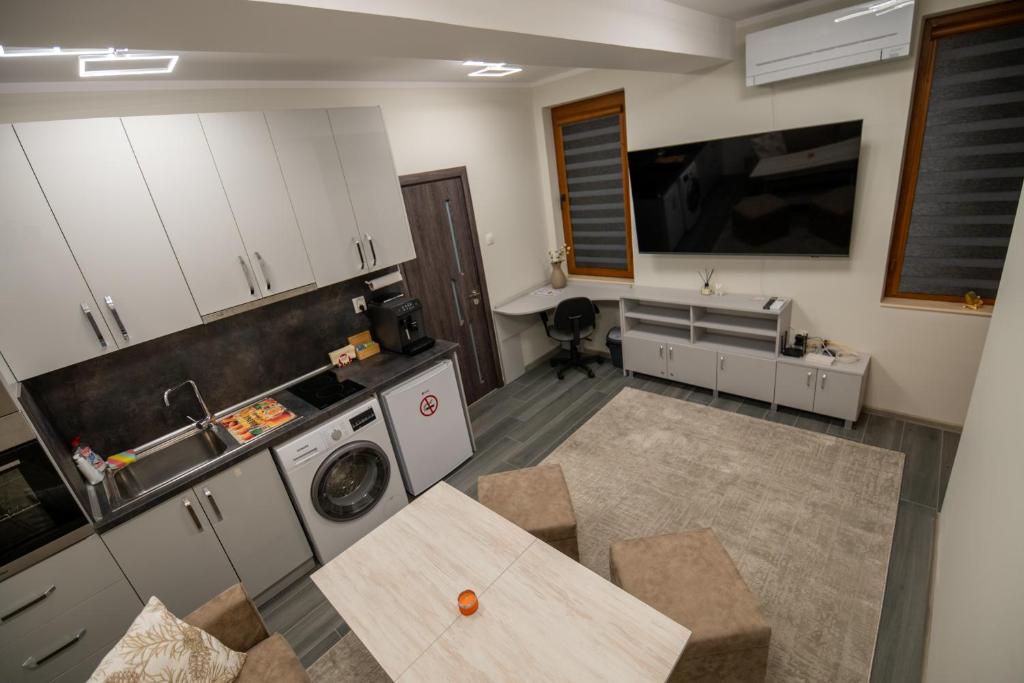 een keuken met een tafel, een wastafel en een fornuis bij Апартамент Милена in Smolyan