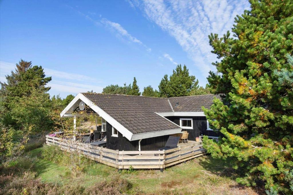una casa con un tetto nero nel bosco di 2556-Romo-Kromosevej-15 a Tagholm