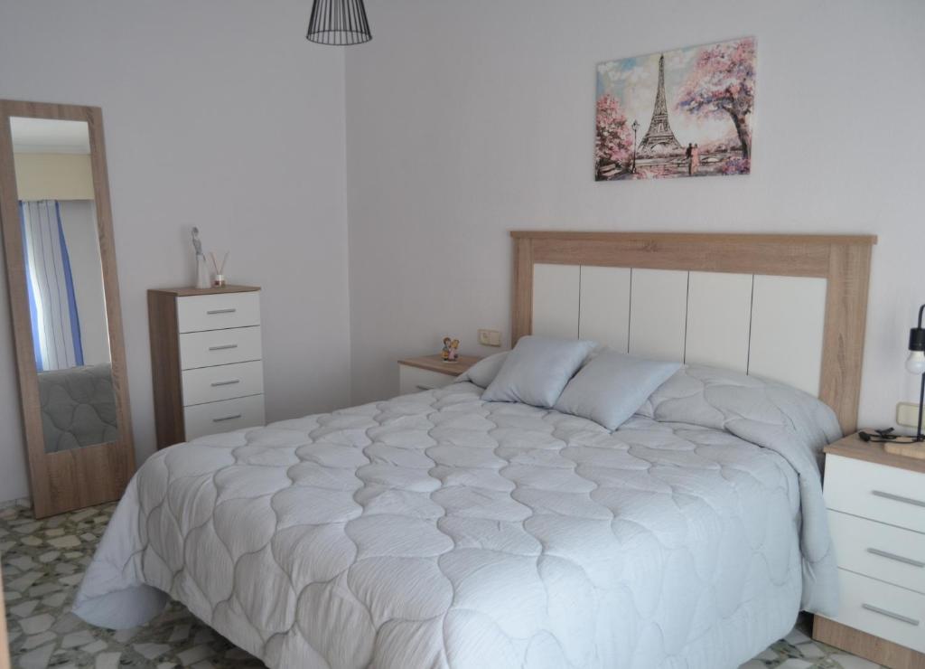 a bedroom with a large white bed and a dresser at Flor de Almendro, cerca de Toledo y Puy du Fou in Portillo de Toledo