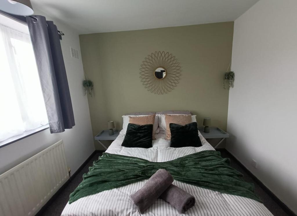 ein Schlafzimmer mit einem Bett mit zwei Kissen und einem Spiegel in der Unterkunft #72 Stylish 3 bedroom sleeps 7 Wigan House in Pemberton