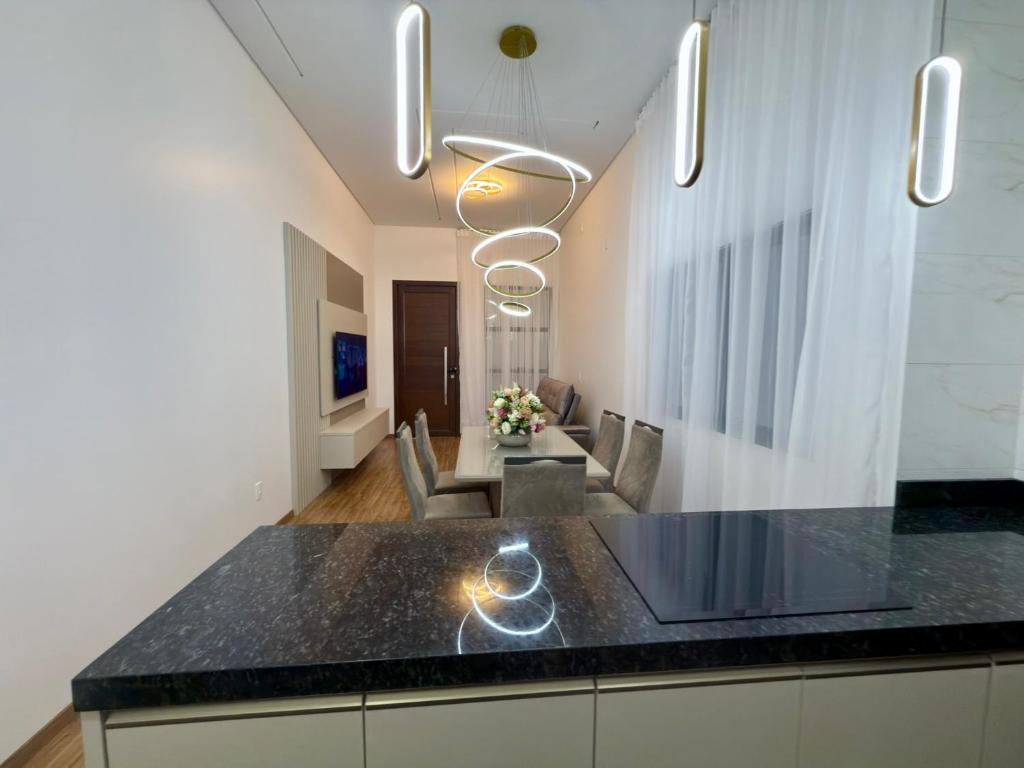 eine Küche mit einer schwarzen Arbeitsplatte und ein Wohnzimmer in der Unterkunft Lar doce lar, 300 metros do centro, 300metros do shopping in Pato Branco