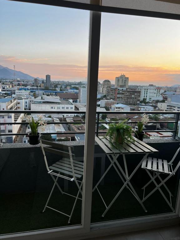 a balcony with a table and chairs and a view of a city at Vista de la cuidad céntrica, ubicado a pasos del mall , restaurantes con excelentes conectivilidad in Rancagua
